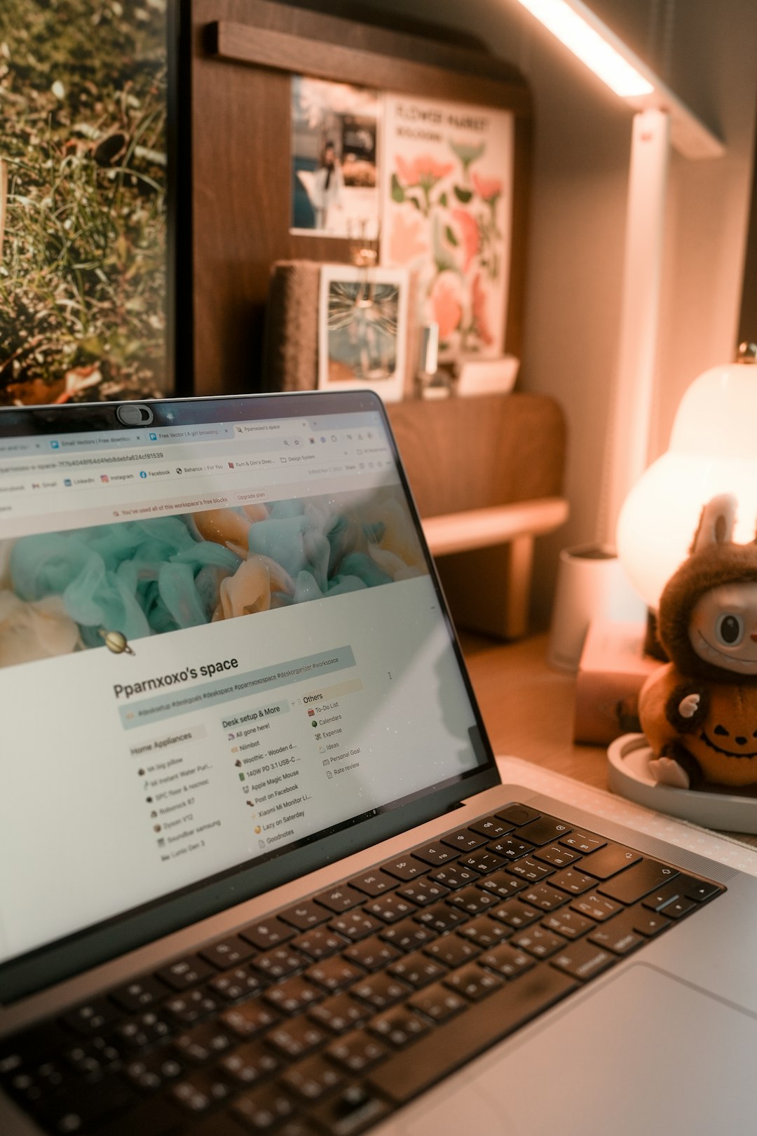 Focused shot of a MacBook with a Notion page, surrounded by cozy desk accessories.